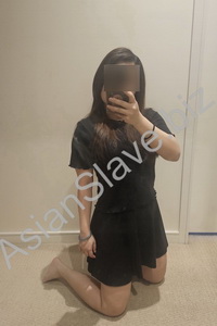 A submissive girl kneels on the floor.